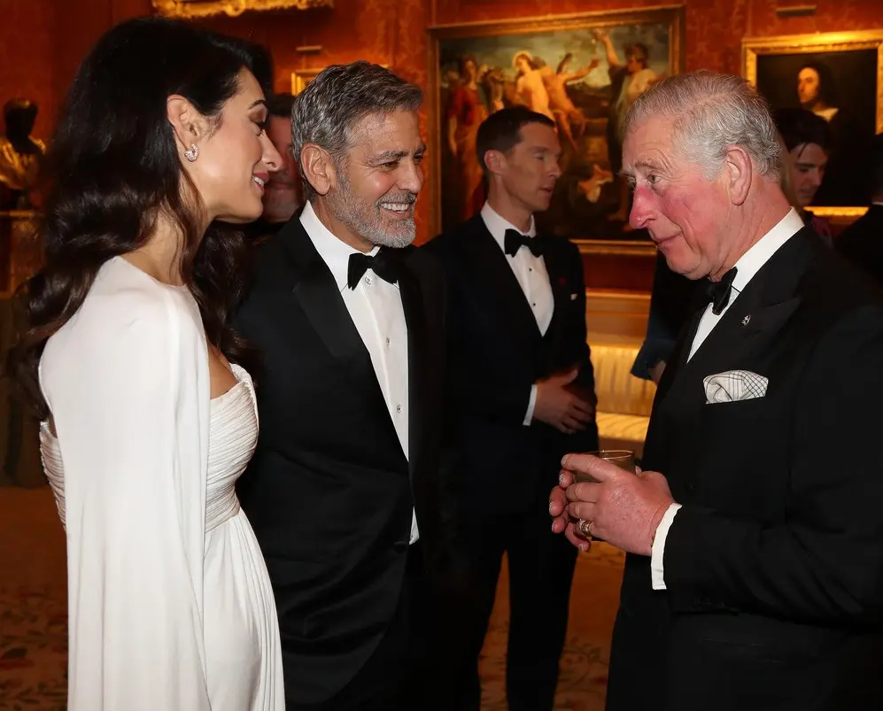 Le prince Charles en conversation avec George et Amal Clooney lors d’une réception en soirée