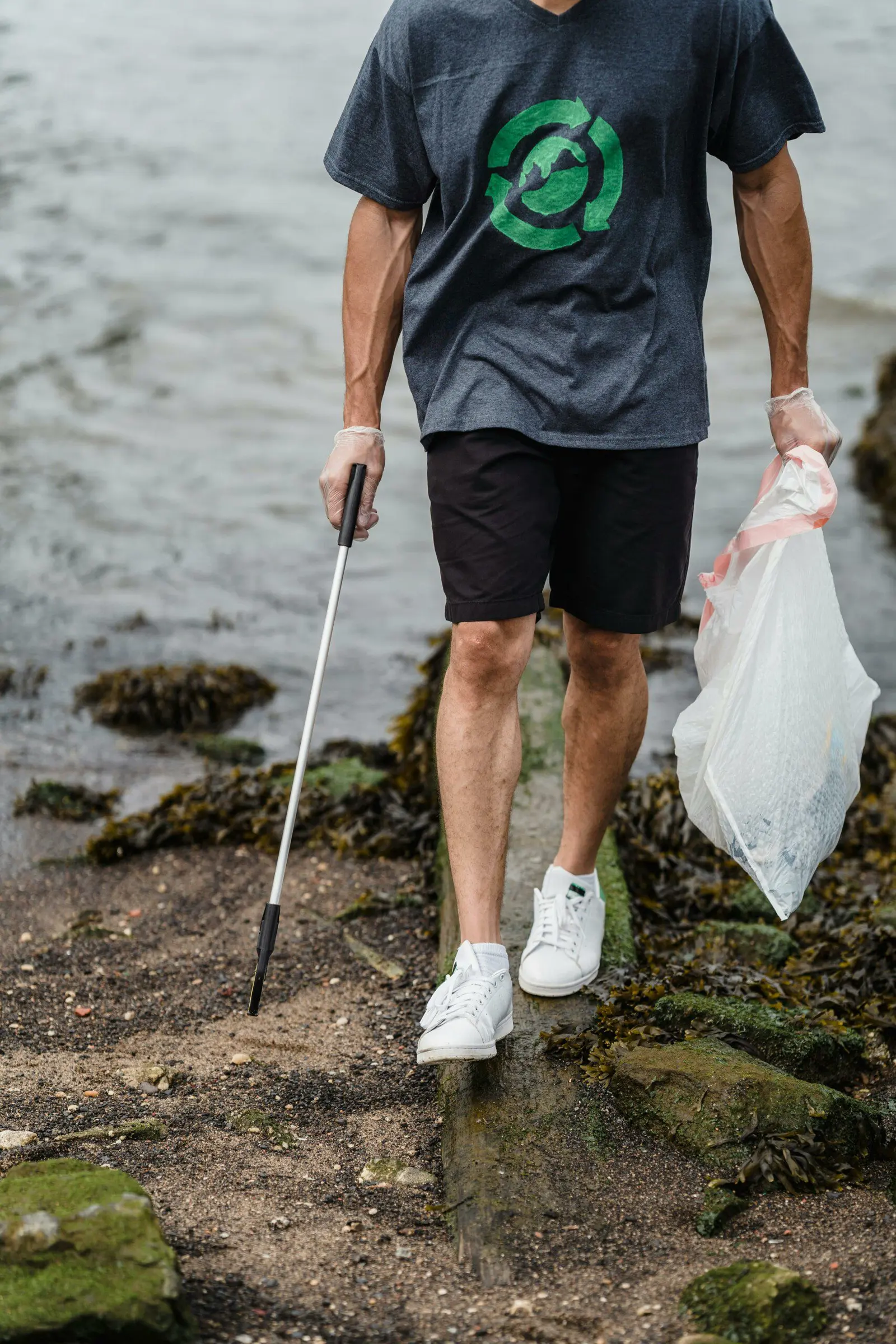 A volunteer collecting litter on a rocky shore