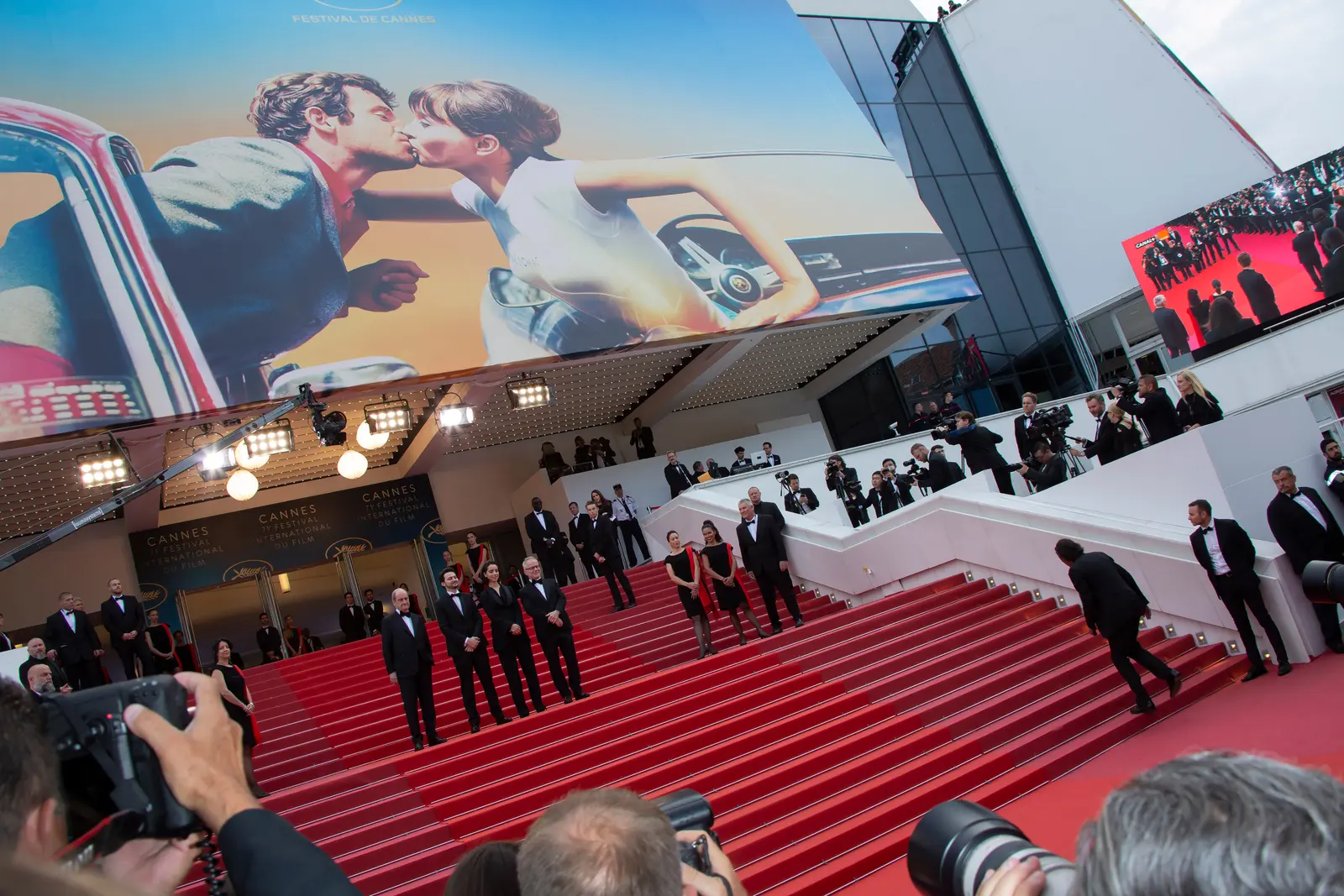The red-carpet steps of the Palais des Festivals in Cannes, lined with photographers, under the festival poster
