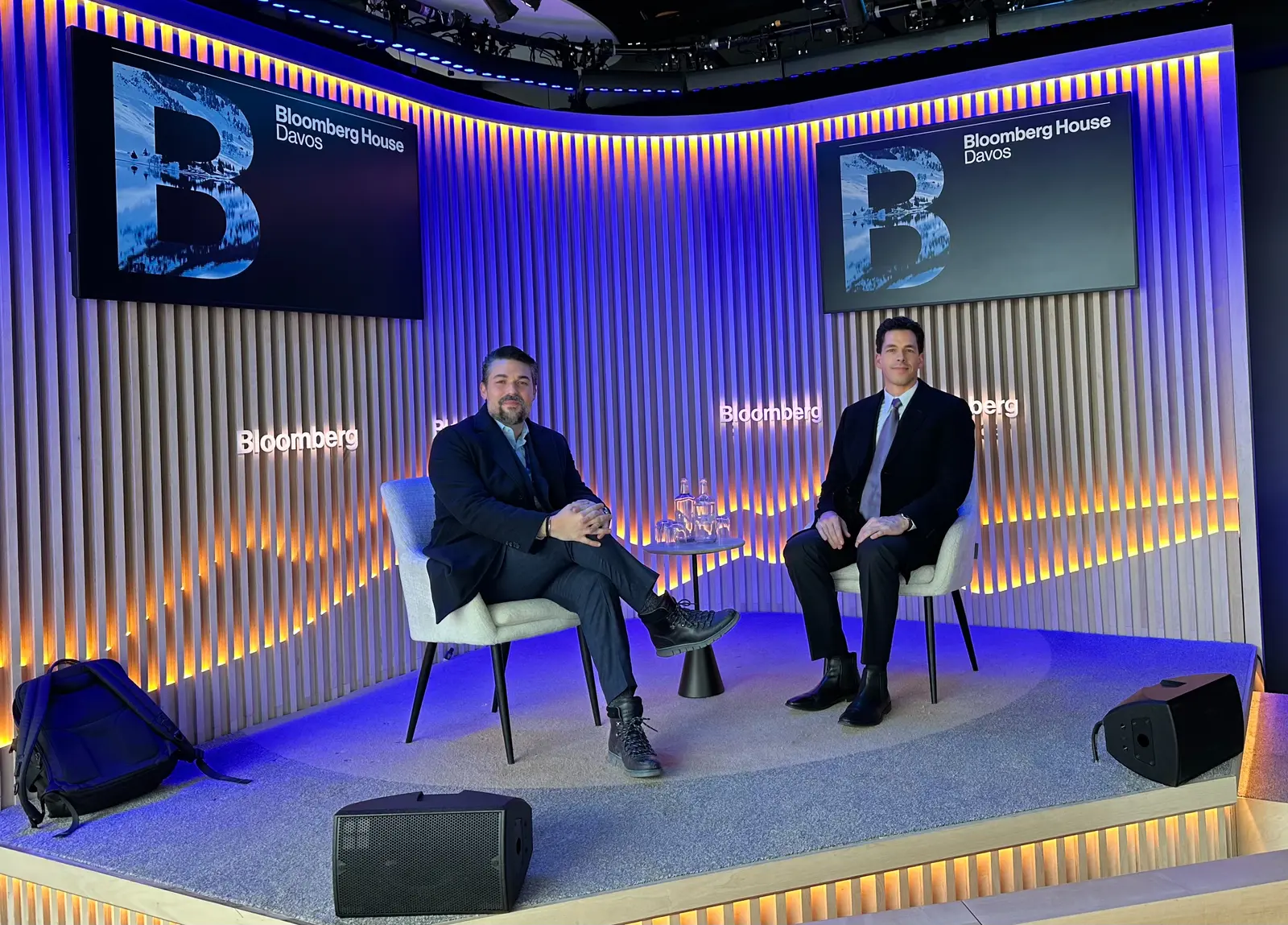 Deux hommes assis sur une scène dans un studio de la Bloomberg House à Davos pendant une interview