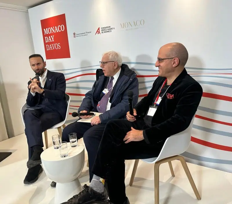 Tassos Economou, David Rubenstein et Jack Hidary assis lors d’un panel devant un fond «&nbsp;Monaco Day Davos&nbsp;»
