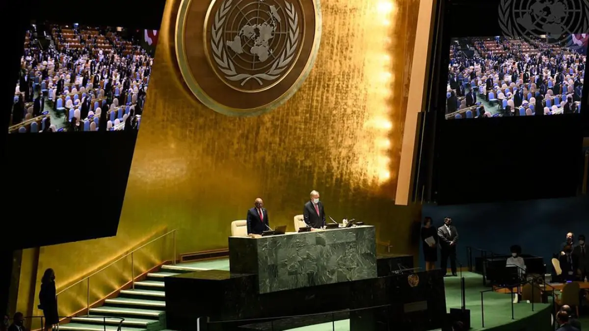 Un orateur à la tribune de la salle de l’Assemblée générale des Nations Unies, devant l’emblème de l’ONU