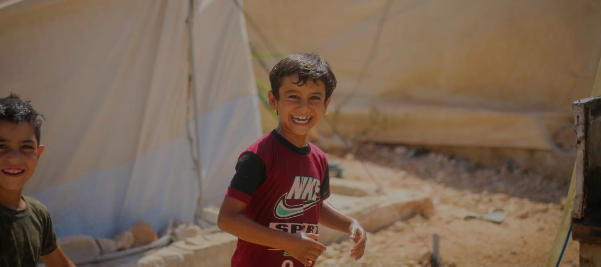 Joyful boy playing in a vibrant community setting, symbolizing The United Society Council's mission of advocating social equity and justice.