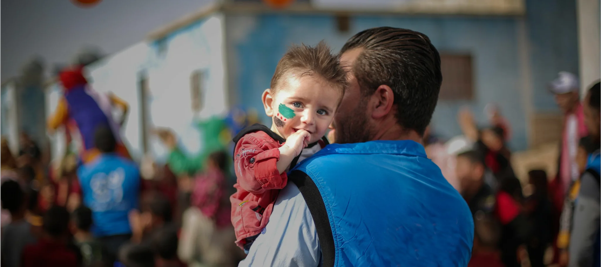 Smiling boy in the arms of a rescue volunteer, resonating with The United Society Council's mission to build resilient futures together.